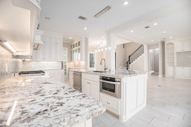 11503 Kings Point Blvd, Mont Belvieu, TX 77535 - kitchen featuring a sink, decorative backsplash, light stone counters, hanging light fixtures, and recessed lighting