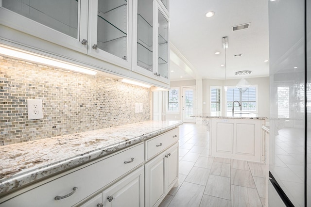 11503 Kings Point Blvd, Mont Belvieu, TX 77535 - kitchen featuring white cabinets, light stone counters, crown molding, backsplash, and recessed lighting