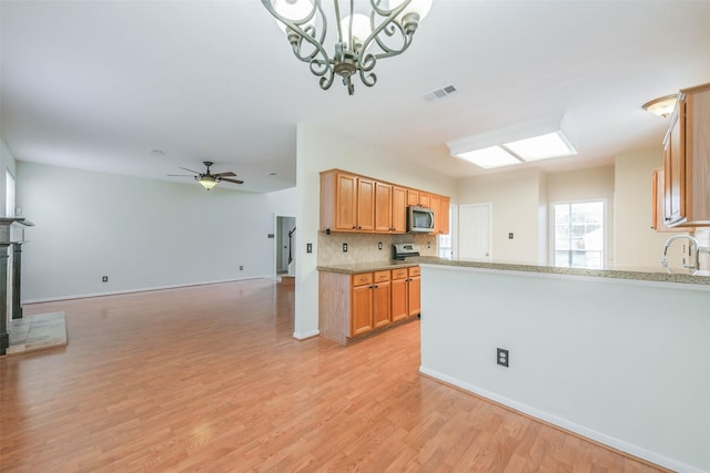 4614 Russett Pl S, Pearland, TX 77584 - kitchen featuring stainless steel microwave, light wood-style floors, a sink, backsplash, and open floor plan
