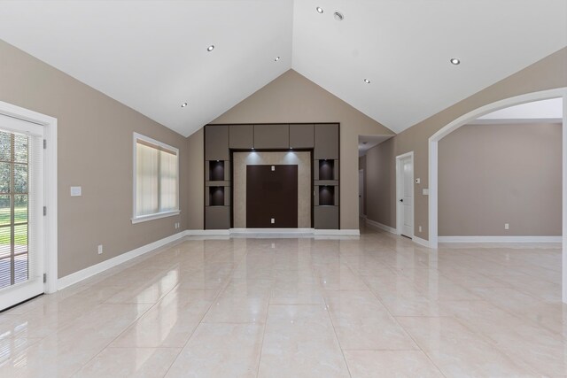 17501 Julianne Dr, Waller, TX 77484 - unfurnished living room featuring arched walkways, baseboards, high vaulted ceiling, built in features, and recessed lighting