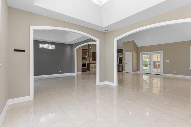 17501 Julianne Dr, Waller, TX 77484 - spare room featuring arched walkways, a chandelier, baseboards, and french doors