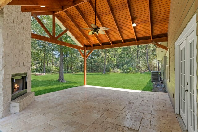 17501 Julianne Dr, Waller, TX 77484 - view of patio / terrace featuring an outdoor stone fireplace, ceiling fan, view of scattered trees, and central air condition unit
