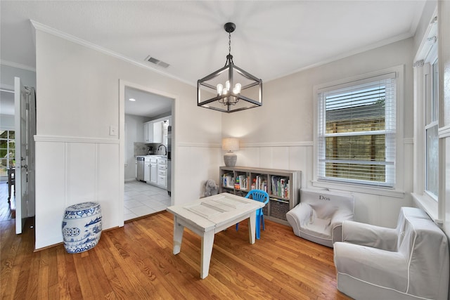 1635 Althea Dr, Houston, TX 77018 - sitting room featuring a chandelier, wood finished floors, plenty of natural light, a wainscoted wall, and ornamental molding