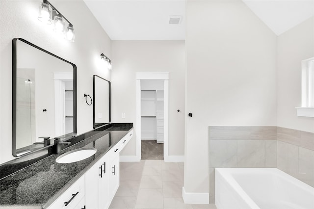 8714 Clarington St, Houston, TX 77016 - full bath featuring a walk in closet, vanity, a garden tub, and baseboards