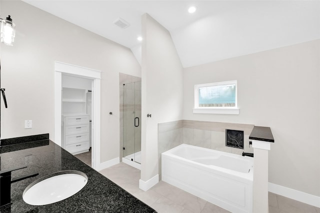 8714 Clarington St, Houston, TX 77016 - full bathroom with a garden tub, a shower stall, a walk in closet, baseboards, and lofted ceiling