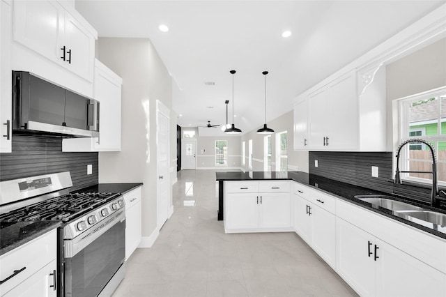 8714 Clarington St, Houston, TX 77016 - kitchen with appliances with stainless steel finishes, a sink, backsplash, ceiling fan, and a peninsula