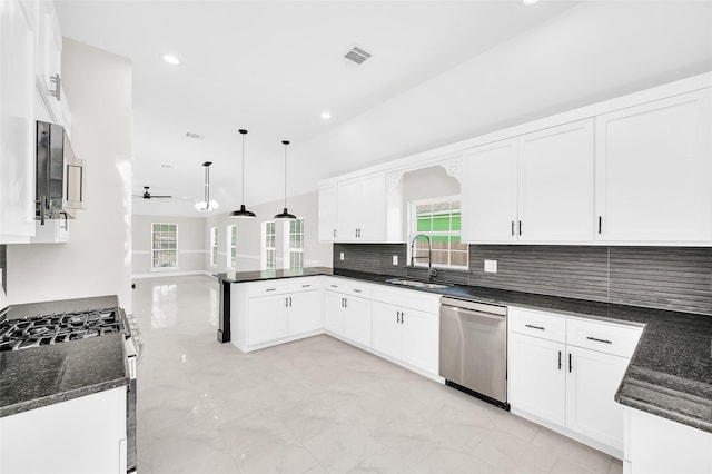 8714 Clarington St, Houston, TX 77016 - kitchen featuring a sink, appliances with stainless steel finishes, a peninsula, white cabinetry, and dark stone counters