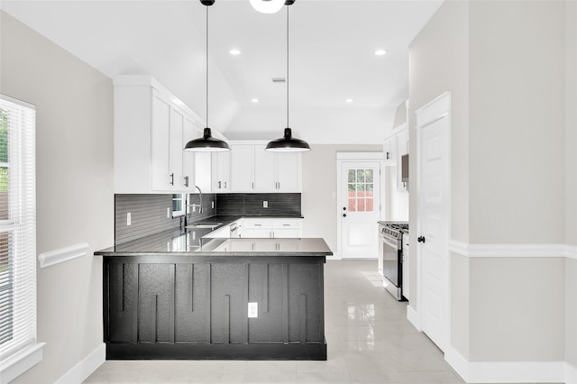 8714 Clarington St, Houston, TX 77016 - kitchen featuring a peninsula, a sink, decorative backsplash, gas stove, and baseboards