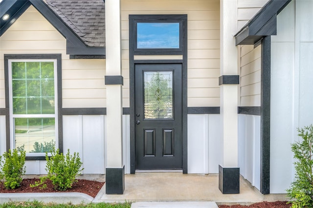 8714 Clarington St, Houston, TX 77016 - doorway to property featuring roof with shingles and board and batten siding