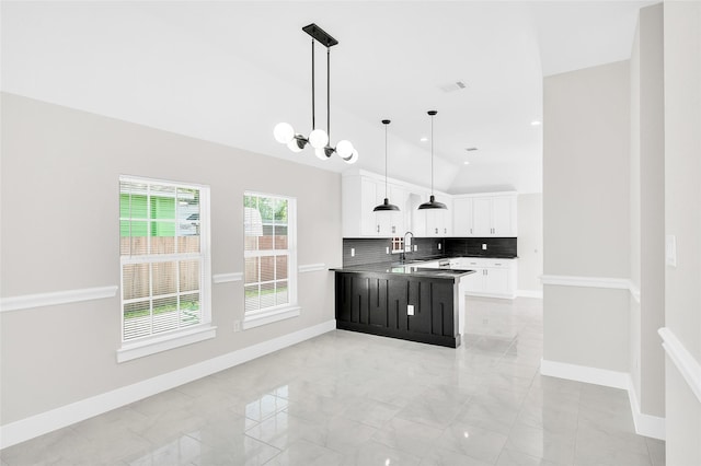 8714 Clarington St, Houston, TX 77016 - kitchen featuring a sink, backsplash, light marble finish floors, white cabinetry, and baseboards