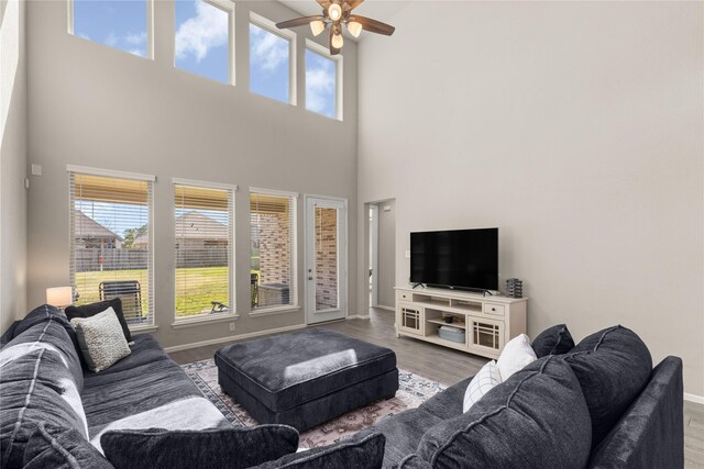 16334 Silver Emperor St, Humble, TX 77346 - living room featuring ceiling fan, healthy amount of natural light, a high ceiling, wood finished floors, and baseboards