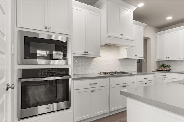 16334 Silver Emperor St, Humble, TX 77346 - kitchen with stainless steel appliances, white cabinetry, decorative backsplash, light countertops, and recessed lighting
