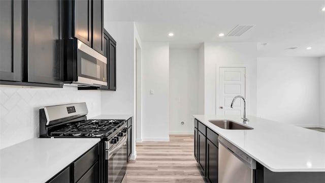 12316 Frisco Cove Ct, Houston, TX 77047 - kitchen with a sink, stainless steel appliances, light countertops, decorative backsplash, and recessed lighting