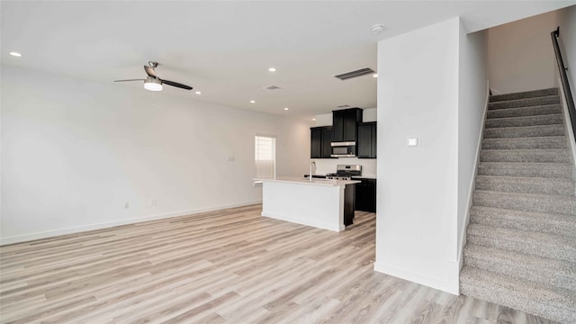 12316 Frisco Cove Ct, Houston, TX 77047 - unfurnished living room featuring ceiling fan, light wood-type flooring, stairs, recessed lighting, and a sink