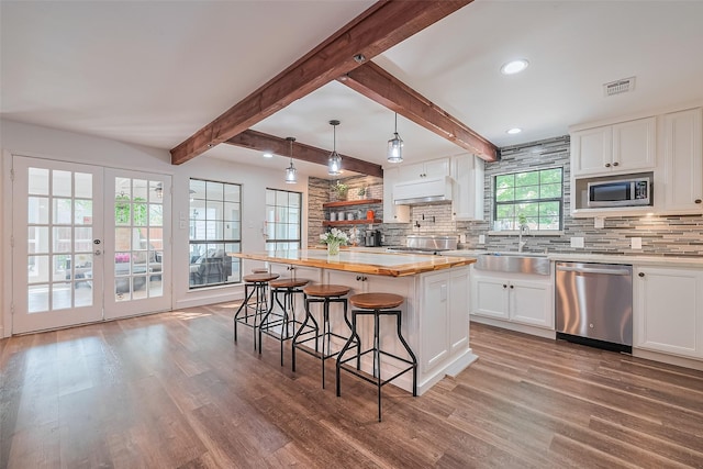 2906 Laurel Fork Dr, Houston, TX 77339 - kitchen featuring appliances with stainless steel finishes, a sink, a breakfast bar, wood finished floors, and decorative backsplash