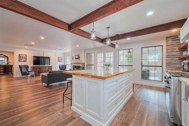 2906 Laurel Fork Dr, Houston, TX 77339 - kitchen featuring stainless steel gas range oven, butcher block countertops, a fireplace, white cabinetry, and recessed lighting