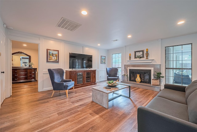 2906 Laurel Fork Dr, Houston, TX 77339 - living room featuring a glass covered fireplace, light wood finished floors, recessed lighting, and a decorative wall