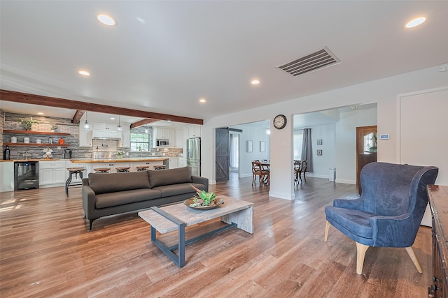 2906 Laurel Fork Dr, Houston, TX 77339 - living area featuring beverage cooler, light wood finished floors, recessed lighting, beamed ceiling, and baseboards