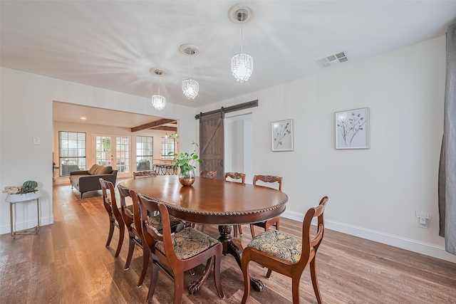 2906 Laurel Fork Dr, Houston, TX 77339 - dining room featuring a barn door, light wood-style floors, and baseboards