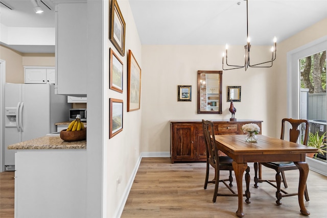 1146 Fountain View Dr Unit 204, Houston, TX 77057 - dining area featuring light wood-type flooring, baseboards, a chandelier, and track lighting