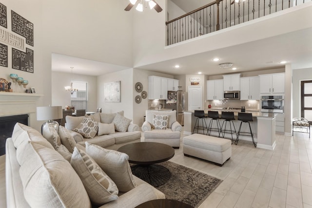 5010 Trembling Aspen Ln, Rosenberg, TX 77471 - living room featuring a high ceiling, a chandelier, ceiling fan, baseboards, and recessed lighting