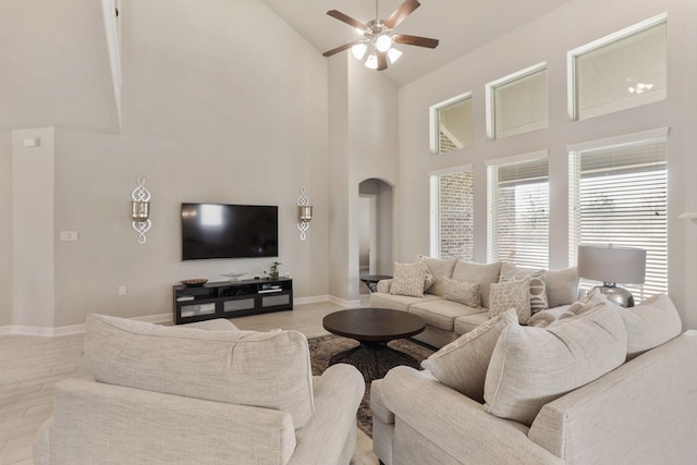 5010 Trembling Aspen Ln, Rosenberg, TX 77471 - living room with arched walkways, ceiling fan, high vaulted ceiling, baseboards, and light wood-style floors