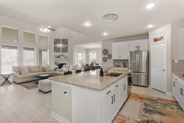 5010 Trembling Aspen Ln, Rosenberg, TX 77471 - kitchen with stainless steel appliances, a sink, a ceiling fan, open floor plan, and an island with sink