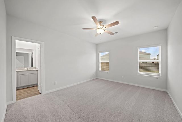 18523 Lilliput Ln, New Caney, TX 77357 - unfurnished bedroom featuring light carpet, ensuite bath, baseboards, and ceiling fan