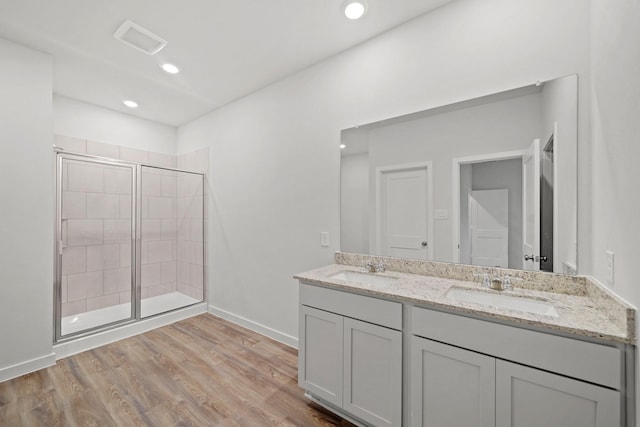 18523 Lilliput Ln, New Caney, TX 77357 - bathroom featuring a shower stall, wood finished floors, double vanity, baseboards, and recessed lighting