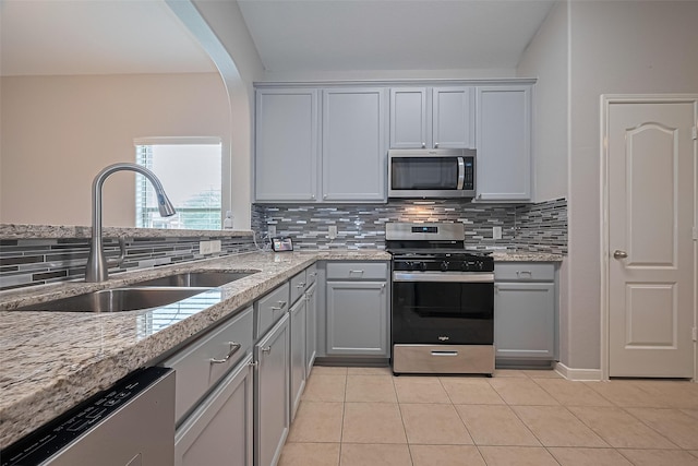 614 Starboard Ct, Katy, TX 77494 - kitchen with appliances with stainless steel finishes, a sink, gray cabinetry, and backsplash