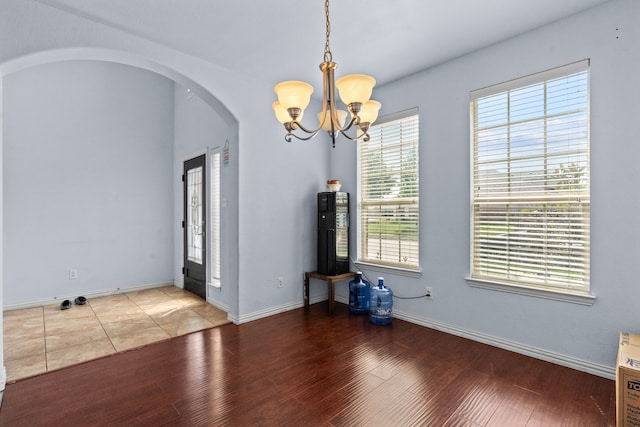 9108 Yellow Cedar Trl, Fort Worth, TX 76244 - unfurnished dining area featuring arched walkways, a chandelier, wood finished floors, and baseboards