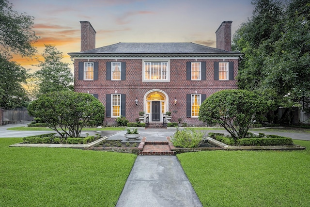 3653 Inverness Dr, Houston, TX 77019 - colonial house featuring a chimney, a lawn, and brick siding