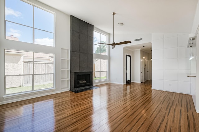 1326 Forest Home Dr, Houston, TX 77077 - unfurnished living room featuring a high ceiling, wood finished floors, ceiling fan, and built in shelves