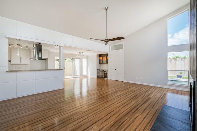 1326 Forest Home Dr, Houston, TX 77077 - unfurnished living room with high vaulted ceiling, wood finished floors, beverage cooler, baseboards, and ceiling fan