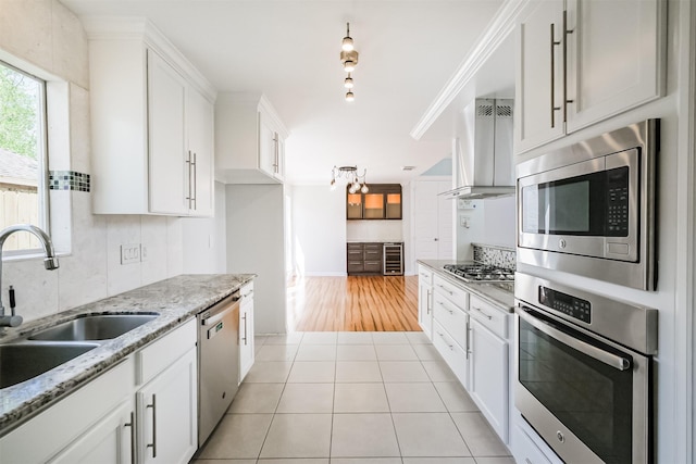 1326 Forest Home Dr, Houston, TX 77077 - kitchen featuring stainless steel appliances, a sink, white cabinetry, light tile patterned floors, and exhaust hood