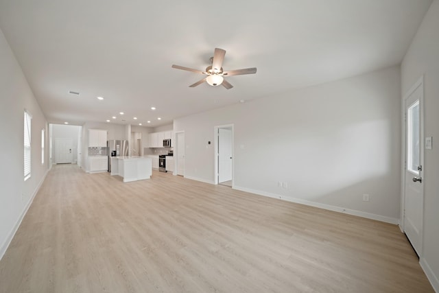 7919 Grand Louis Way, Spring, TX 77379 - unfurnished living room with ceiling fan, light wood finished floors, and recessed lighting
