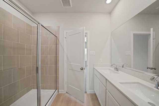 7919 Grand Louis Way, Spring, TX 77379 - full bath featuring double vanity, a tile shower, and wood finished floors
