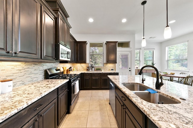 126 Biltmore Loop, Montgomery, TX 77316 - kitchen featuring stainless steel appliances, a sink, decorative backsplash, light stone countertops, and dark brown cabinetry