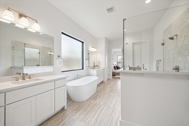 403 Venado View Ct, Conroe, TX 77304 - bathroom featuring tiled shower, ensuite bathroom, a freestanding bath, vanity, and recessed lighting