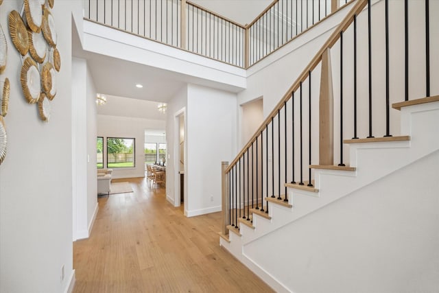 403 Venado View Ct, Conroe, TX 77304 - stairway featuring baseboards, wood finished floors, a towering ceiling, and recessed lighting