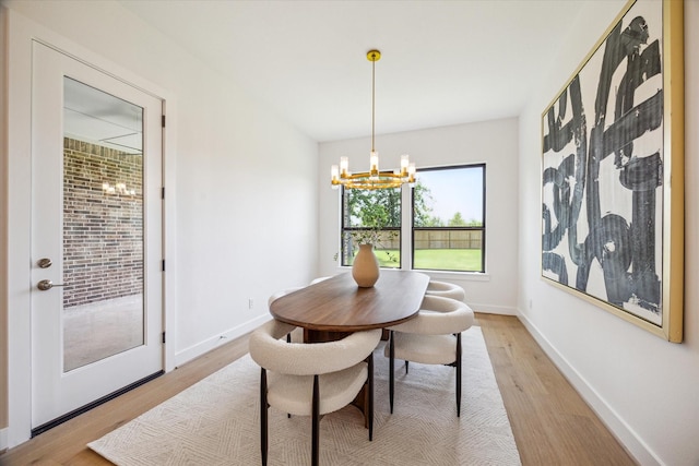 403 Venado View Ct, Conroe, TX 77304 - dining area featuring a chandelier, light wood-style flooring, and baseboards