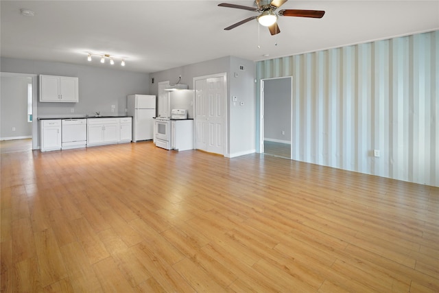 3541 Mount Pleasant St, Houston, TX 77021 - unfurnished living room featuring a ceiling fan, a sink, light wood-type flooring, and baseboards