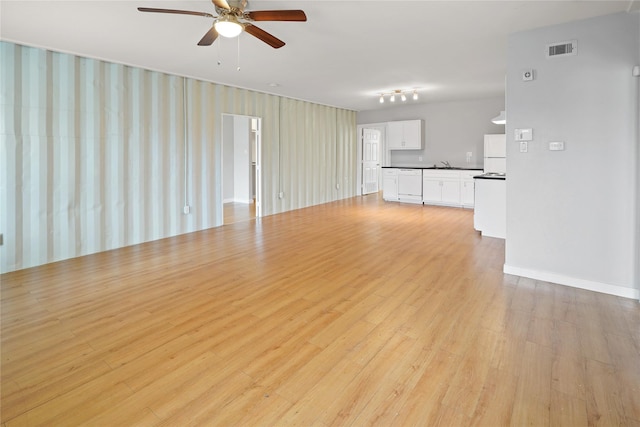 3541 Mount Pleasant St, Houston, TX 77021 - unfurnished living room with ceiling fan, light wood finished floors, a sink, and baseboards