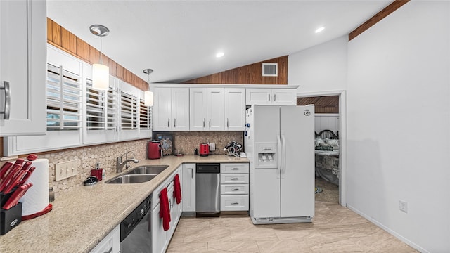 1417 8th St, San Leon, TX 77539 - kitchen with white refrigerator with ice dispenser, vaulted ceiling, a sink, tasteful backsplash, and stainless steel dishwasher