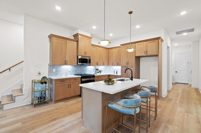 6705 Del Rio St, Houston, TX 77021 - kitchen with stainless steel microwave, light wood-type flooring, tasteful backsplash, light countertops, and recessed lighting