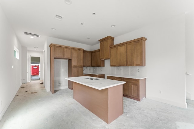 6705 Del Rio St, Houston, TX 77021 - kitchen with brown cabinets, a center island, unfinished concrete floors, and recessed lighting