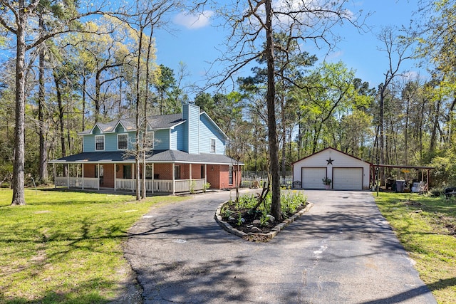 9219 Sendera Dr, Magnolia, TX 77354 - view of front of property with an outdoor structure, asphalt driveway, covered porch, and a chimney