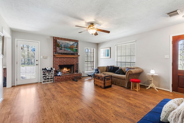 9219 Sendera Dr, Magnolia, TX 77354 - living area featuring a fireplace, ceiling fan, wood finished floors, a textured ceiling, and baseboards
