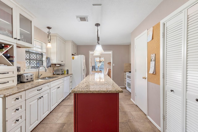 9219 Sendera Dr, Magnolia, TX 77354 - kitchen featuring a sink, white appliances, backsplash, a center island, and a chandelier