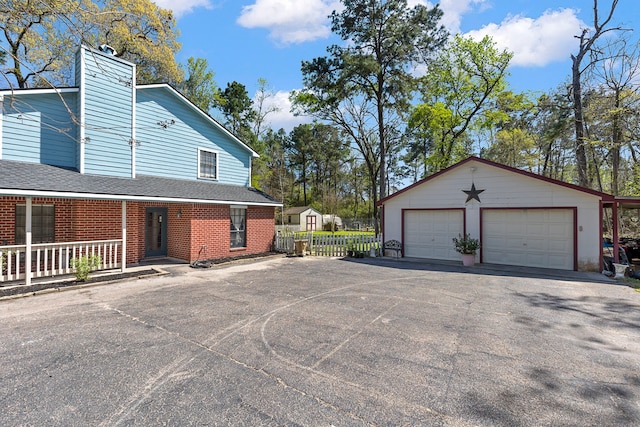 9219 Sendera Dr, Magnolia, TX 77354 - view of property exterior featuring an outbuilding, a garage, brick siding, a porch, and a chimney
